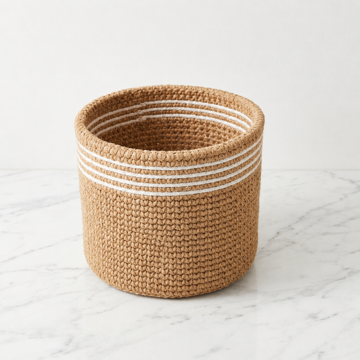 Boho jute planter basket with white stripes, front view on a white background